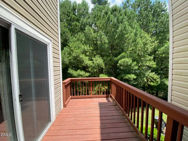 a balcony with wooden floor in front of a house