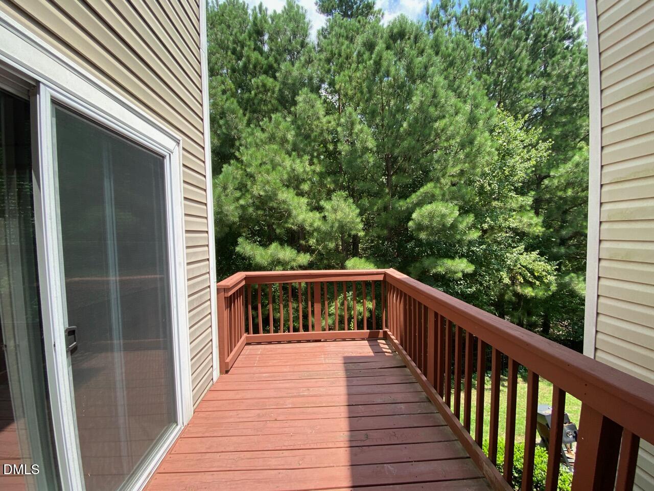134 Darley Dale Loop Apex, NC 27502 - Photo 22 of 23 a balcony with wooden floor in front of a house