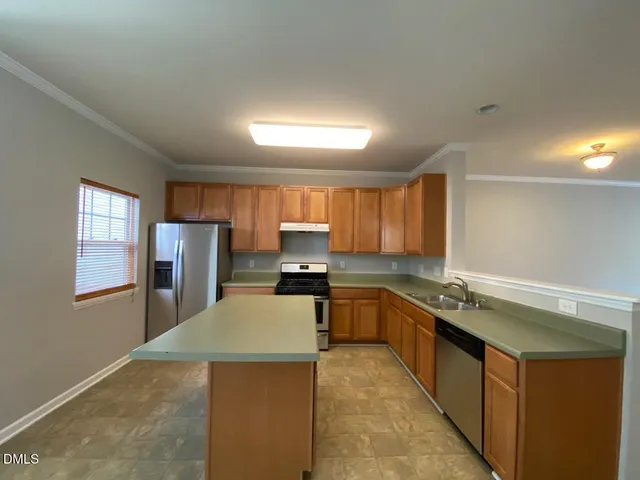 a kitchen with stainless steel appliances granite countertop a sink counter space and a window