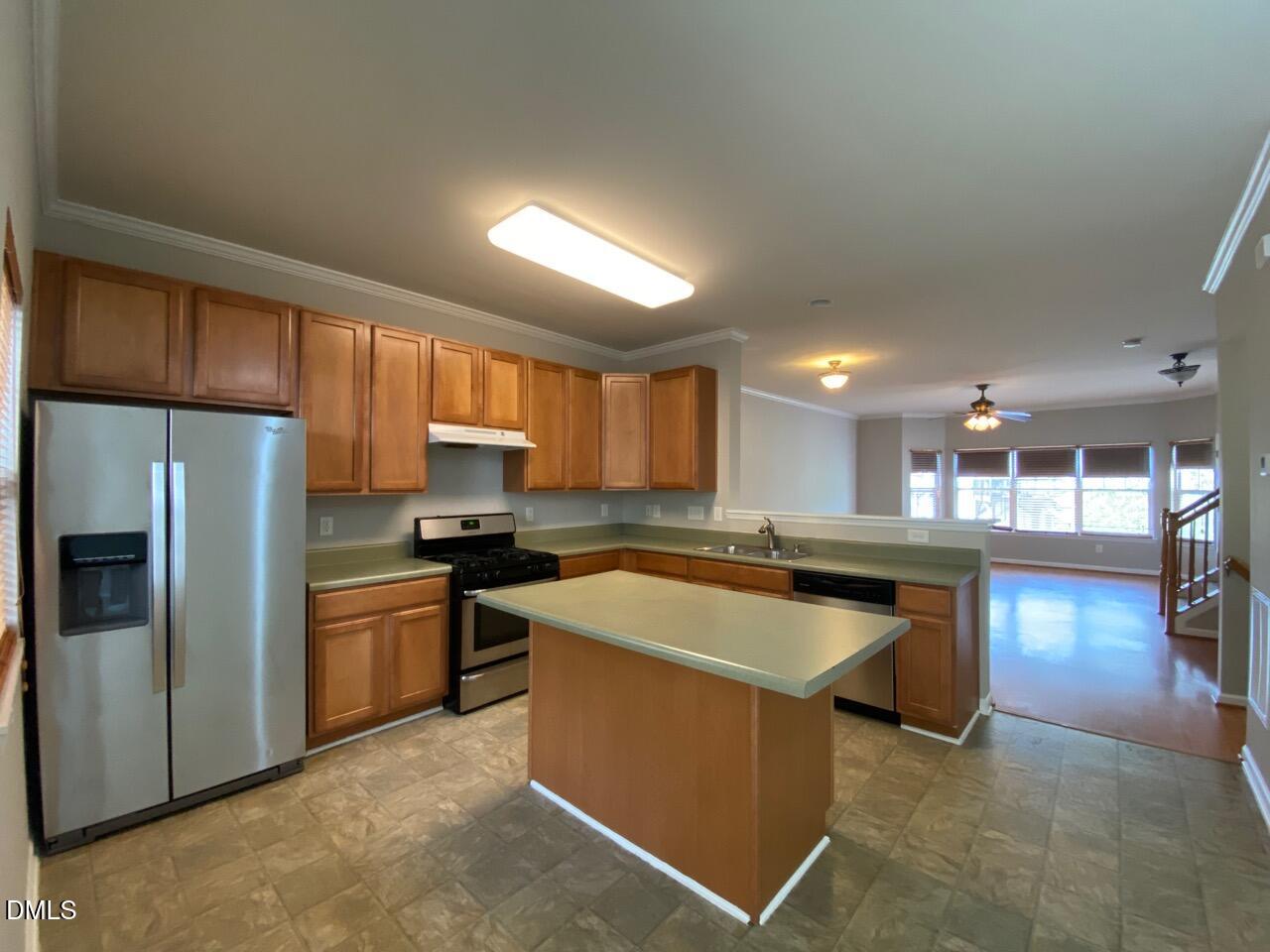 134 Darley Dale Loop Apex, NC 27502 - Photo 9 of 23 a kitchen with stainless steel appliances granite countertop a sink stove and refrigerator