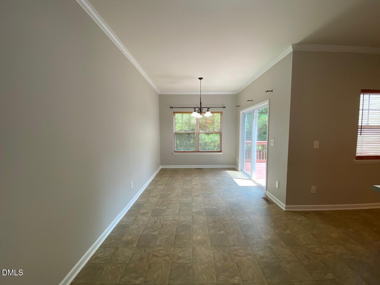 134 Darley Dale Loop Apex, NC 27502 - Photo 10 of 23 an empty room with windows and chandelier