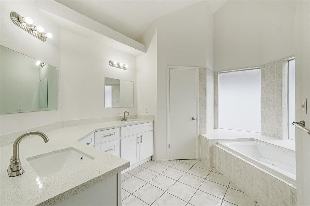 6235 West Willow Bluff Road Katy, TX 77449 - Photo 12 of 18 a spacious bathroom with a bathtub sink and mirror