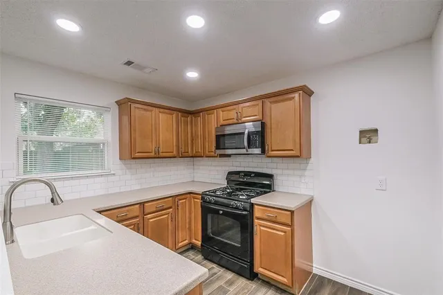 a kitchen that has a sink and a stove top oven