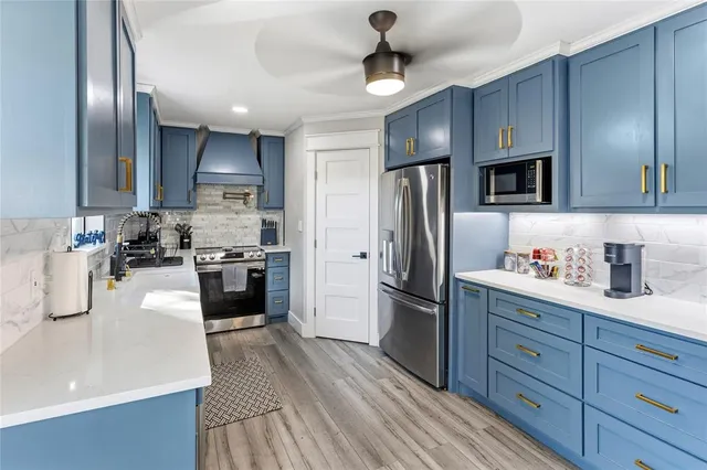 a kitchen with kitchen island granite countertop stainless steel appliances and wooden cabinets