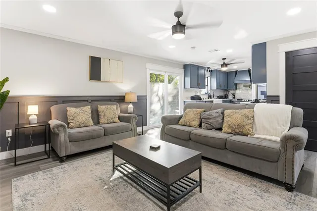 a living room with furniture a ceiling fan and a rug