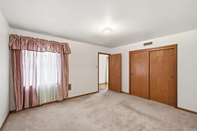 an empty room with windows and closet area
