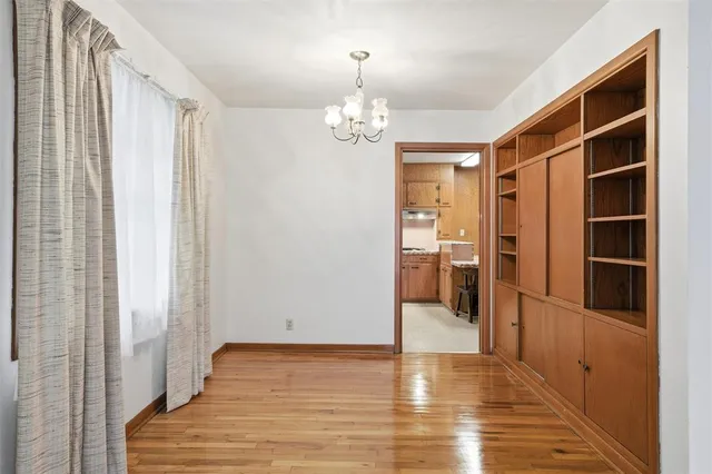a view of empty room with wooden floor and cabinet