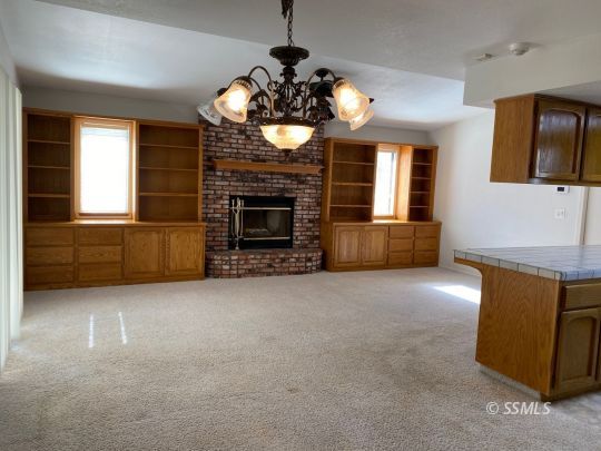 718 North Inyo Street Ridgecrest, CA 93555 - Photo 4 of 9 a view of an empty room with a fireplace and a window