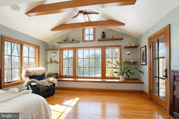 a bedroom with a large bed and a flat tv screen on dresser
