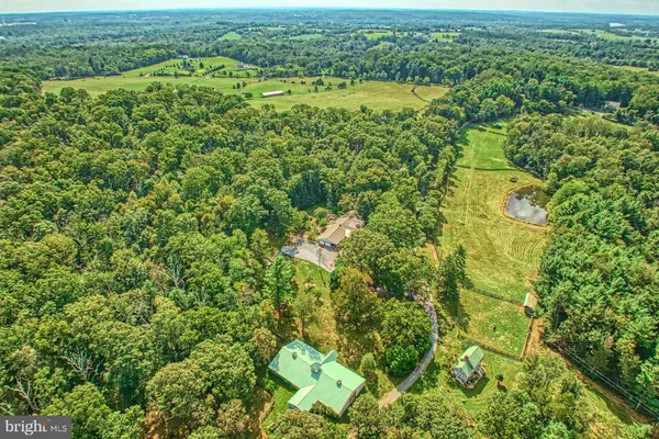 an aerial view of residential houses with outdoor space and trees