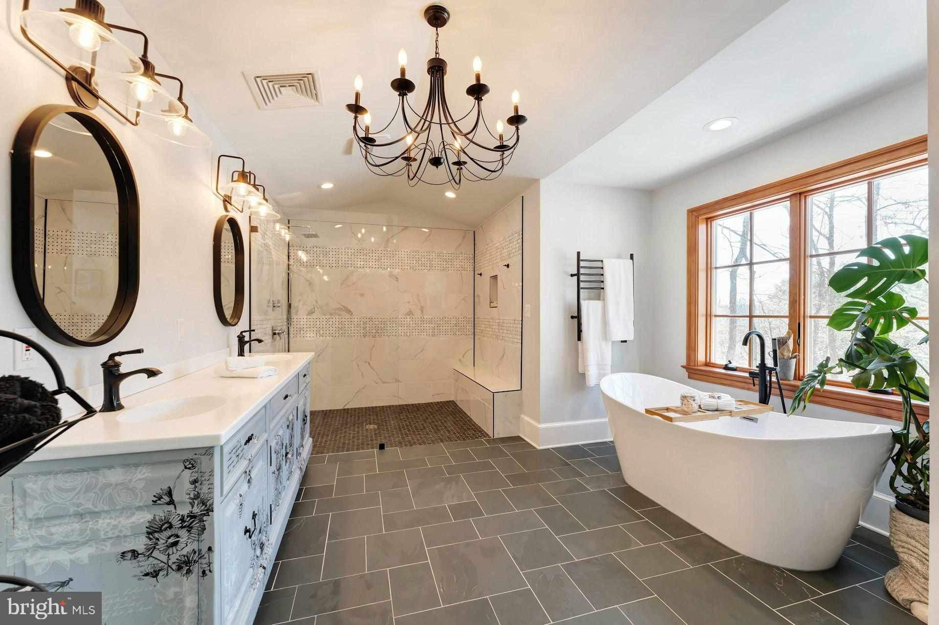 43470 Evans Pond Road Leesburg, VA 20176 - Photo 32 of 114 a spacious bathroom with a double vanity sink a mirror a bathtub and a window