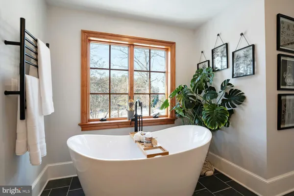 a bathroom with a tub sink and mirror