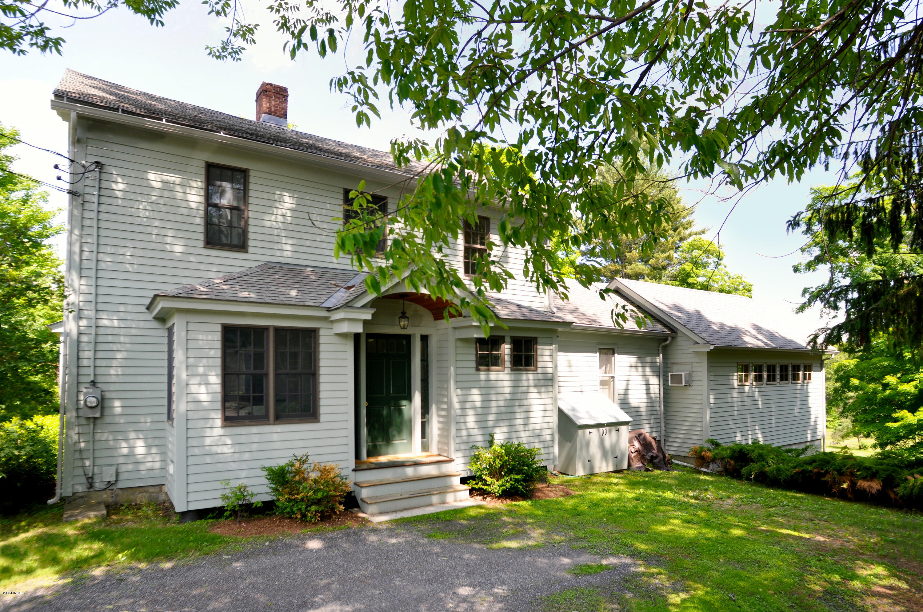210 Main Road Monterey, MA 01245 - Photo 1 of 33 a front view of a house with a garden and plants