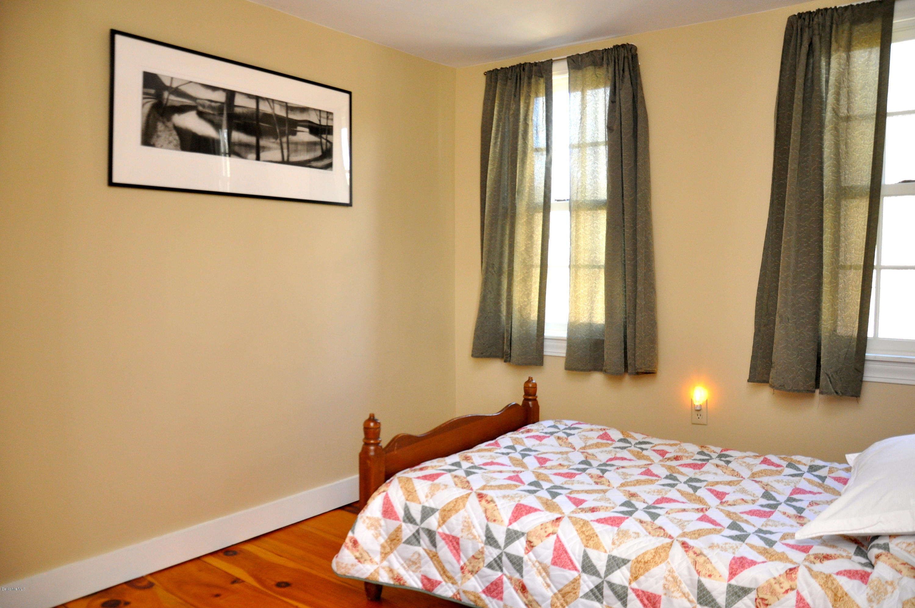 210 Main Road Monterey, MA 01245 - Photo 15 of 33 a bedroom with a bed and a lamp next to a window