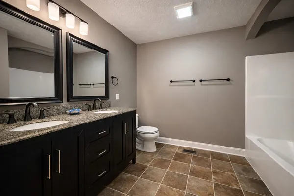 an empty room with wooden floor chandelier fan and windows