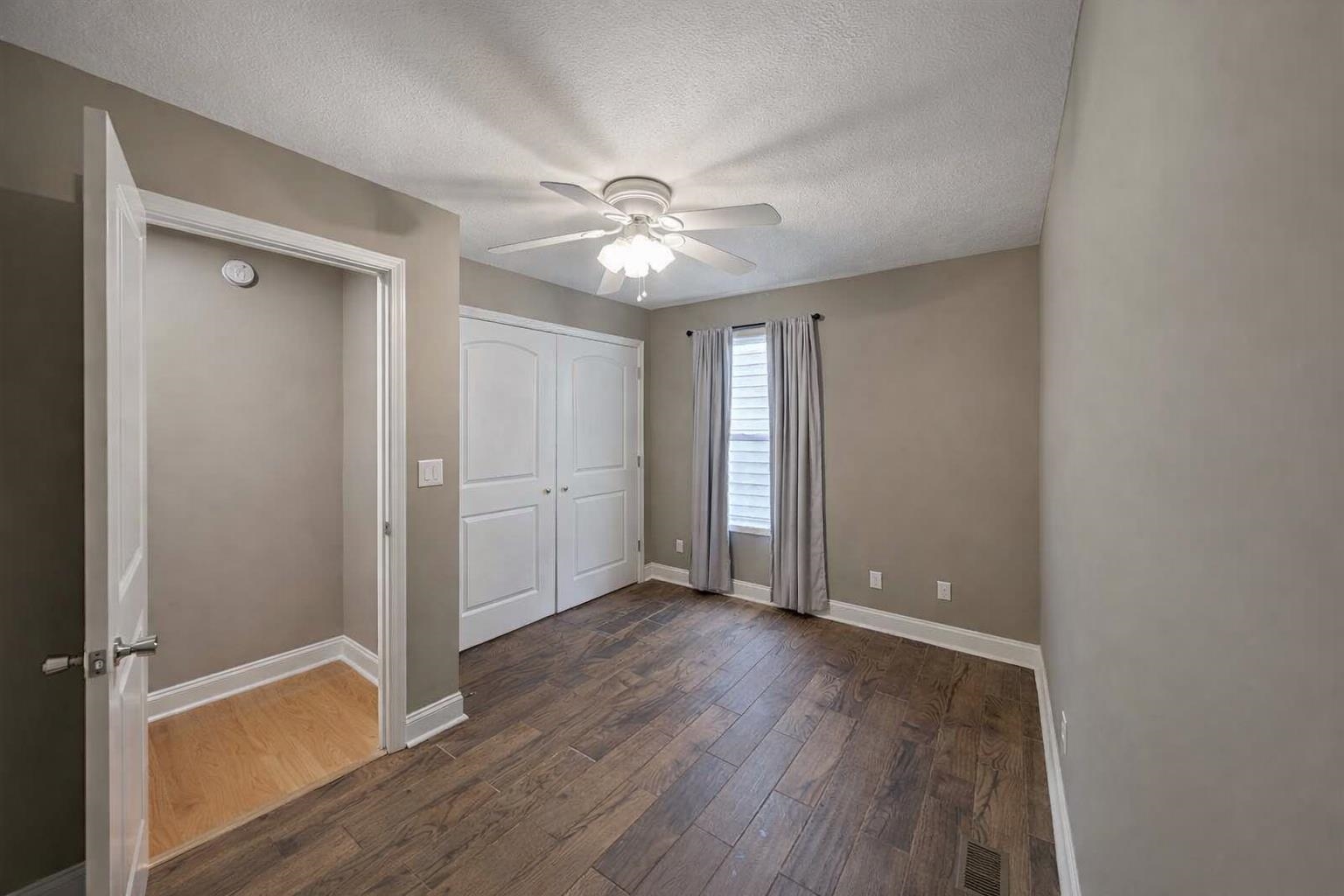 60 Masters Court Counce, TN 38326 - Photo 15 of 30 Unfurnished bedroom with a textured ceiling, dark wood-style floors, ceiling fan, and a closet