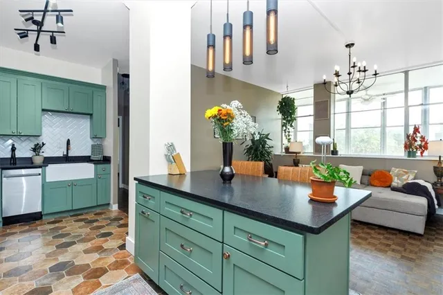 a kitchen with stainless steel appliances kitchen island granite countertop a sink dishwasher and cabinets