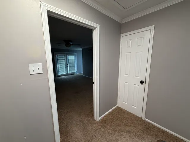 an empty room with windows and chandelier fan