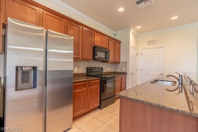 8887 Ravello Court Naples, FL 34114 - Photo 12 of 22 Kitchen featuring black appliances, ornamental molding, sink, and stone countertops