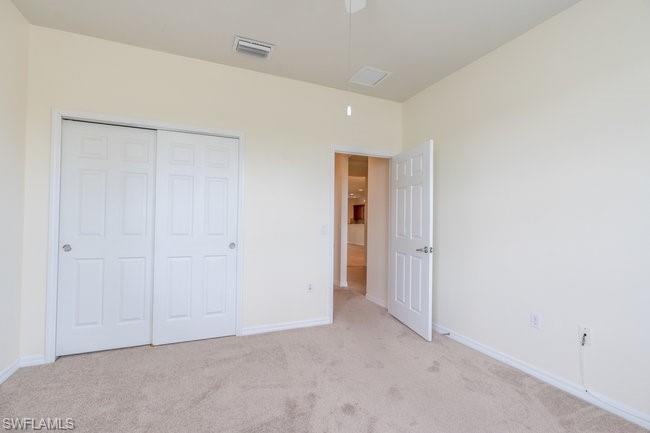 8887 Ravello Court Naples, FL 34114 - Photo 20 of 22 Unfurnished bedroom featuring light colored carpet and a closet