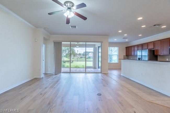 8887 Ravello Court Naples, FL 34114 - Photo 8 of 22 Unfurnished living room featuring light wood-type flooring, ornamental molding, and ceiling fan