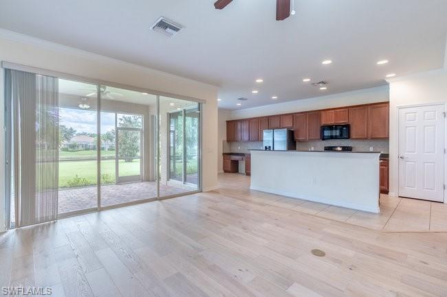 8887 Ravello Court Naples, FL 34114 - Photo 9 of 22 Kitchen featuring a center island with sink, crown molding, ceiling fan, light hardwood / wood-style flooring, and stainless steel refrigerator with ice dispenser