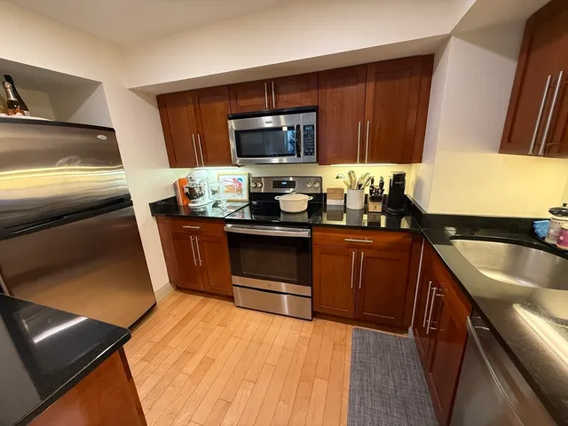 a kitchen with granite countertop stainless steel appliances and wooden cabinets