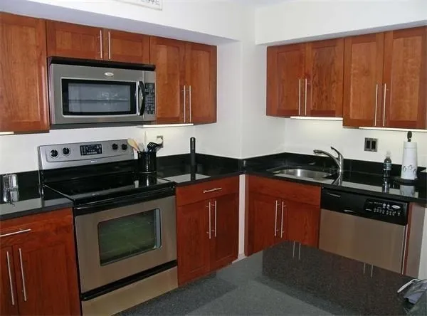 a kitchen with stainless steel appliances a stove a microwave sink and cabinets