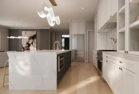 a large white kitchen with a large counter top cabinets and stainless steel appliances