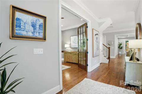 a view of a hallway with wooden floor and a living room