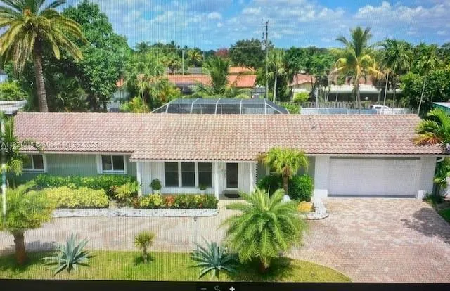 a front view of a house with a yard and potted plants
