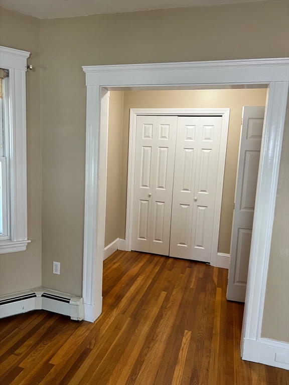 84 Melrose Street, Unit 1 Arlington, MA 02474 - Photo 13 of 42 a view of an empty room with wooden floor and a window
