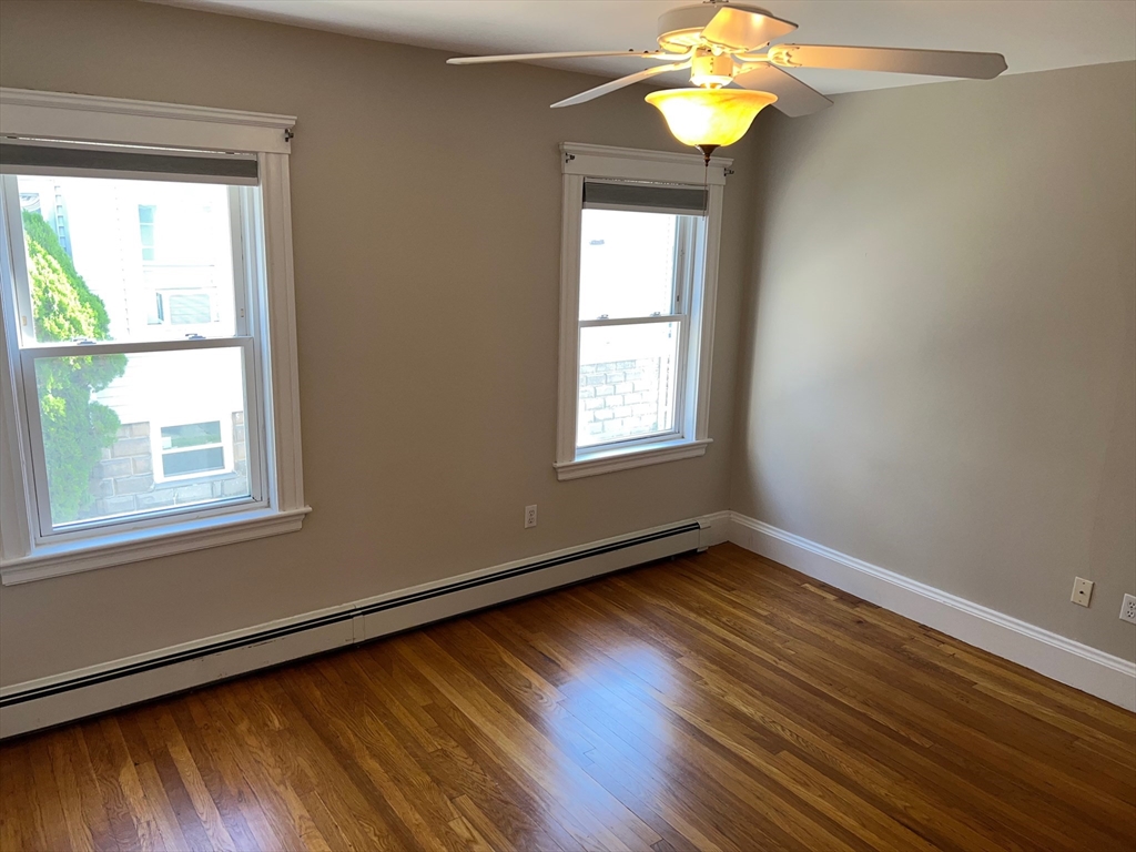 84 Melrose Street, Unit 1 Arlington, MA 02474 - Photo 22 of 42 a view of an empty room with wooden floor and a window