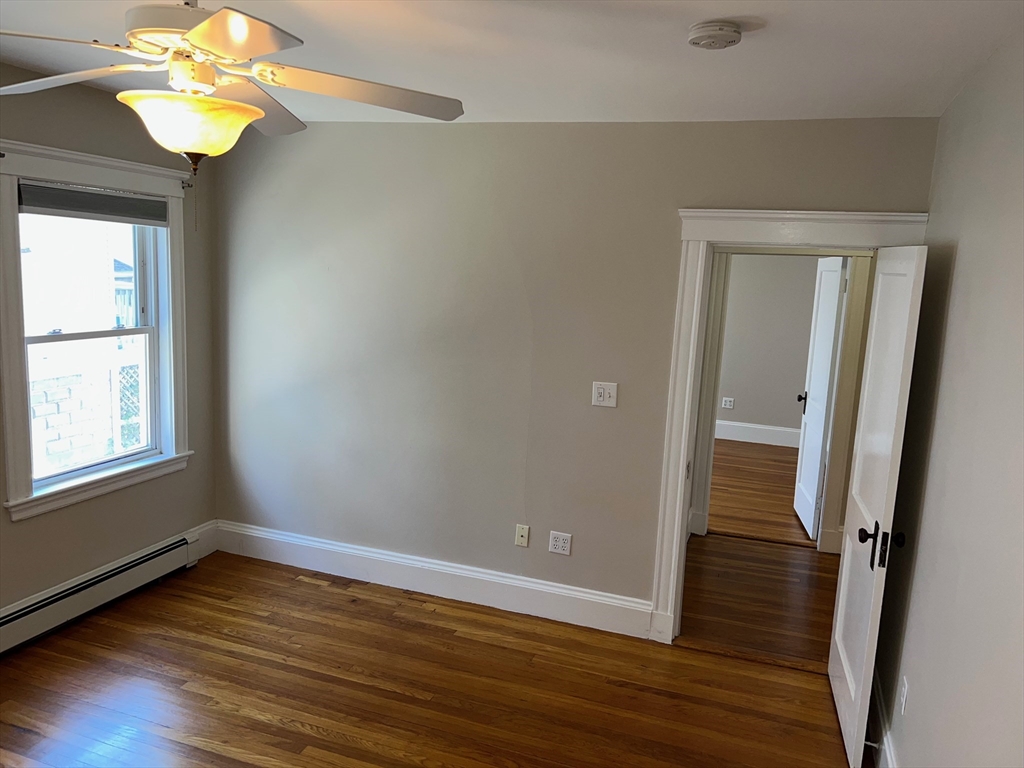 84 Melrose Street, Unit 1 Arlington, MA 02474 - Photo 23 of 42 a view of an empty room with wooden floor and a window