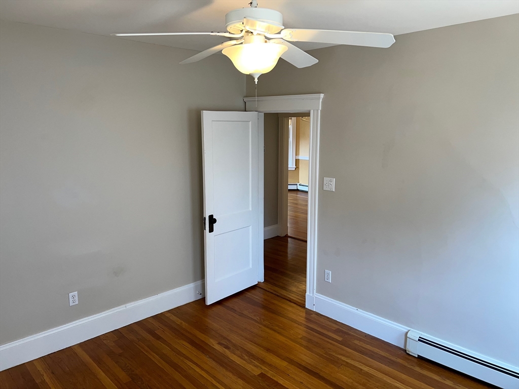 84 Melrose Street, Unit 1 Arlington, MA 02474 - Photo 26 of 42 a view of an empty room with window and wooden floor