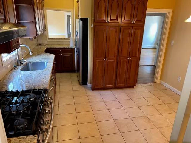 a view of a refrigerator and wooden cabinets