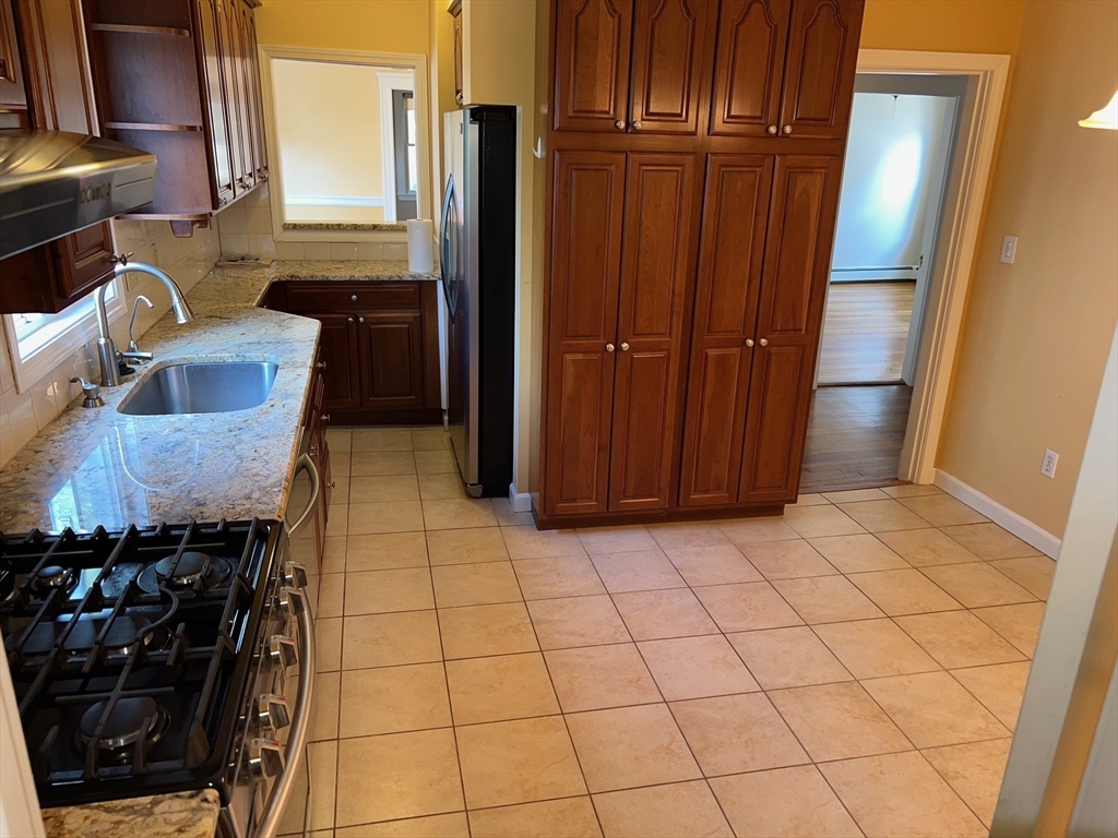 84 Melrose Street, Unit 1 Arlington, MA 02474 - Photo 30 of 42 a view of a refrigerator and wooden cabinets