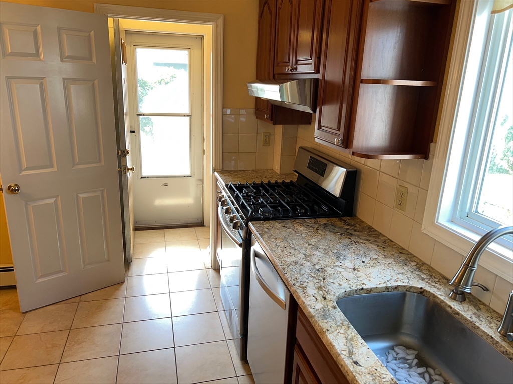 84 Melrose Street, Unit 1 Arlington, MA 02474 - Photo 31 of 42 a kitchen with granite countertop a sink stove and refrigerator