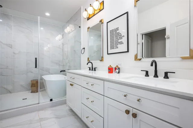 a bathroom with a double vanity sink toilet and shower