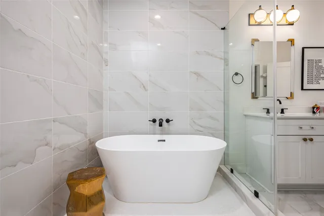 a white bath tub sitting in a bathroom and sink
