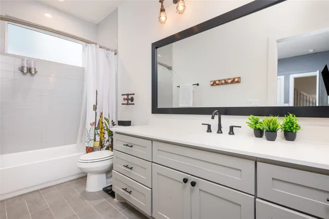 a bathroom with a granite countertop toilet sink and mirror