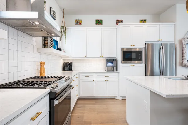 a kitchen with granite countertop a sink stove and refrigerator