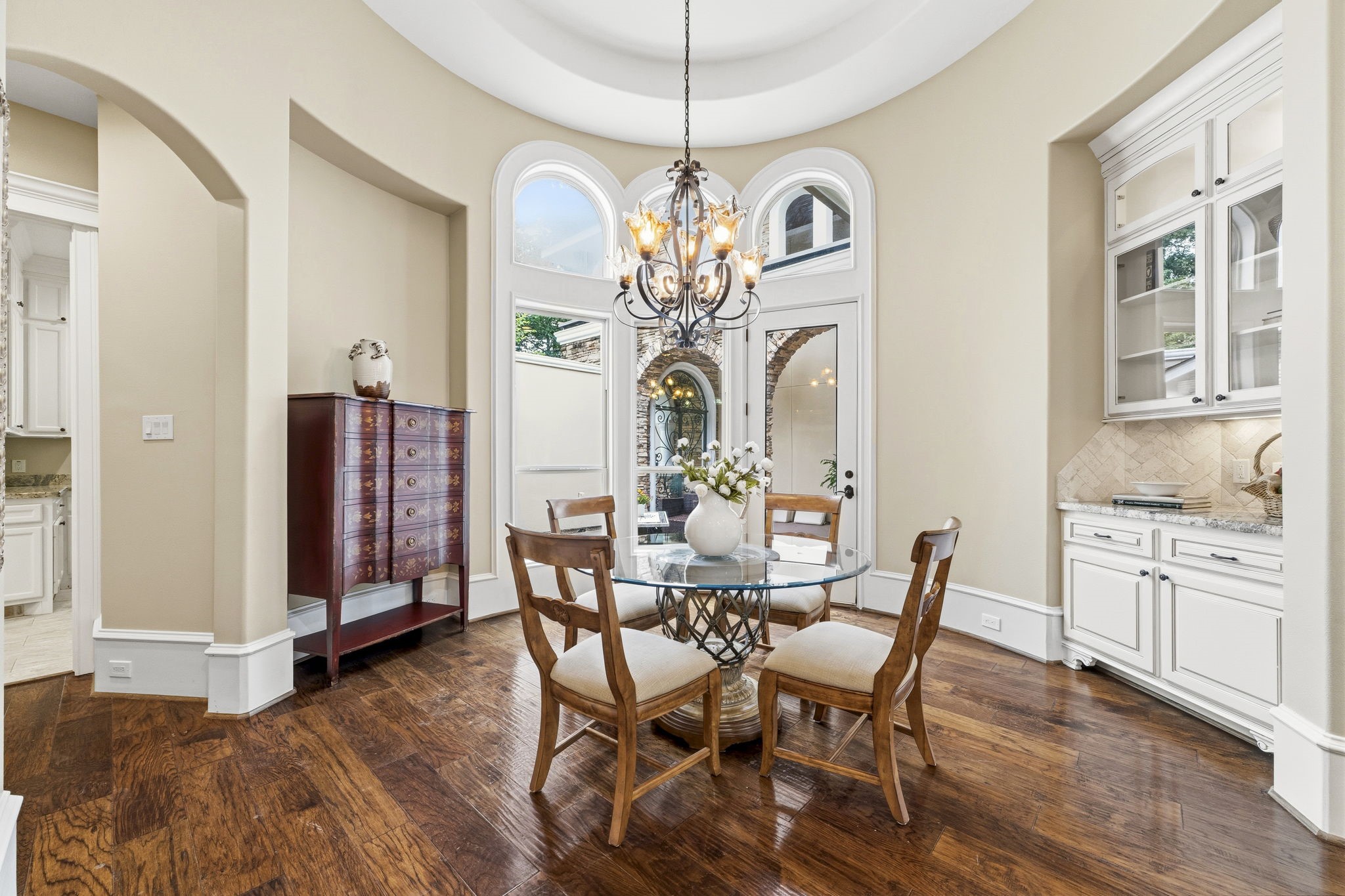 27402 Jacob's Path Lane Spring, TX 77386 - Photo 20 of 48 The breakfast room showcases beautiful architectural details, including graceful curved walls, custom built-in cabinetry, and a thoughtfully designed niche perfect for displaying a favorite piece of furniture. This inviting space also offers direct access to the front courtyard sitting area, providing the perfect setting to enjoy morning coffee or relax by the outdoor fireplace in the evening.