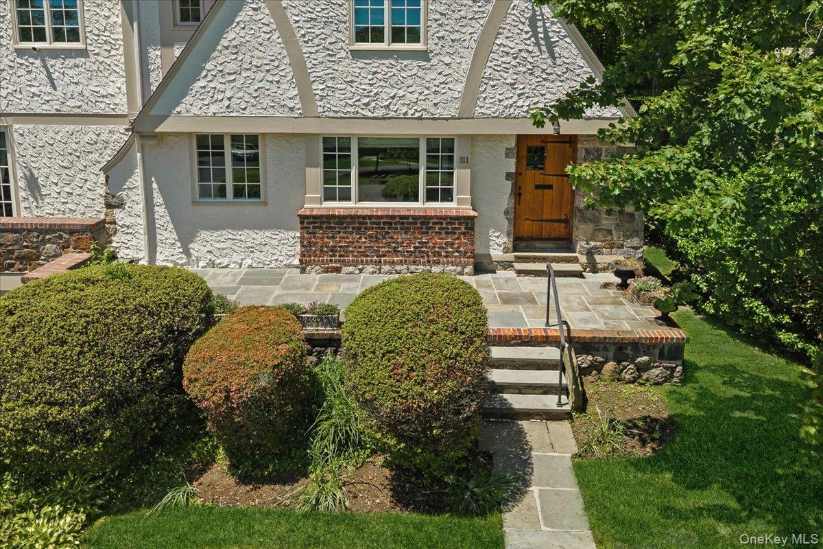 311 Lyncroft Road New Rochelle, NY 10804 - Photo 4 of 39 front view of a house with a garden