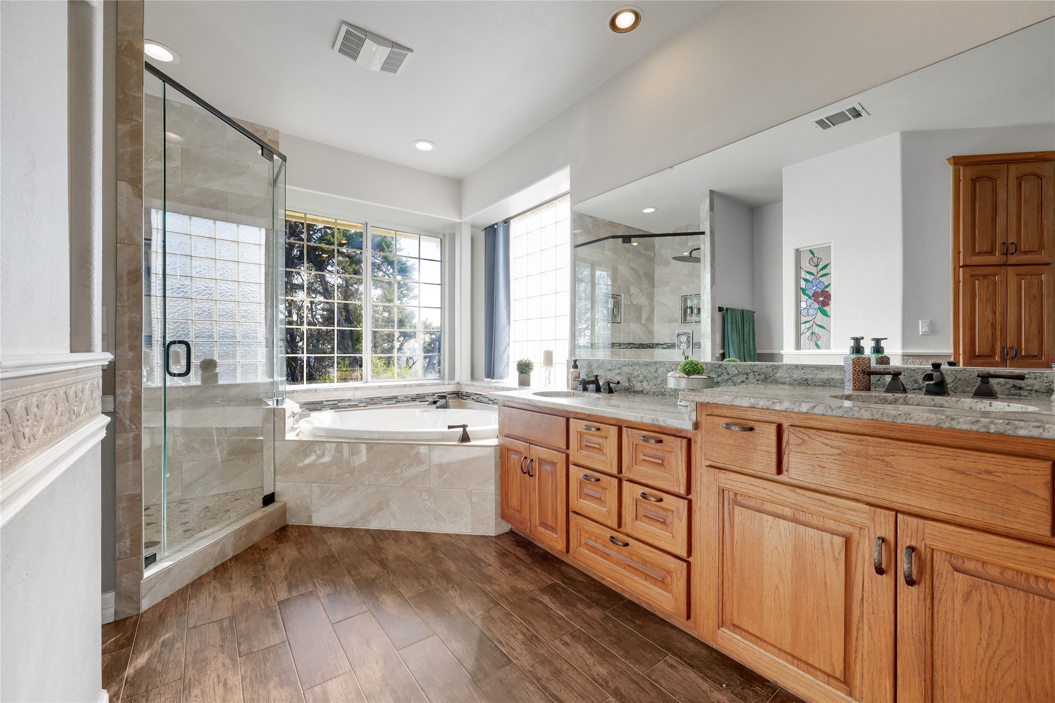 18607 White Rim Trail Jonestown, TX 78645 - Photo 21 of 40 Bathroom with a shower stall, a bath, double vanity, and dark wood-style flooring