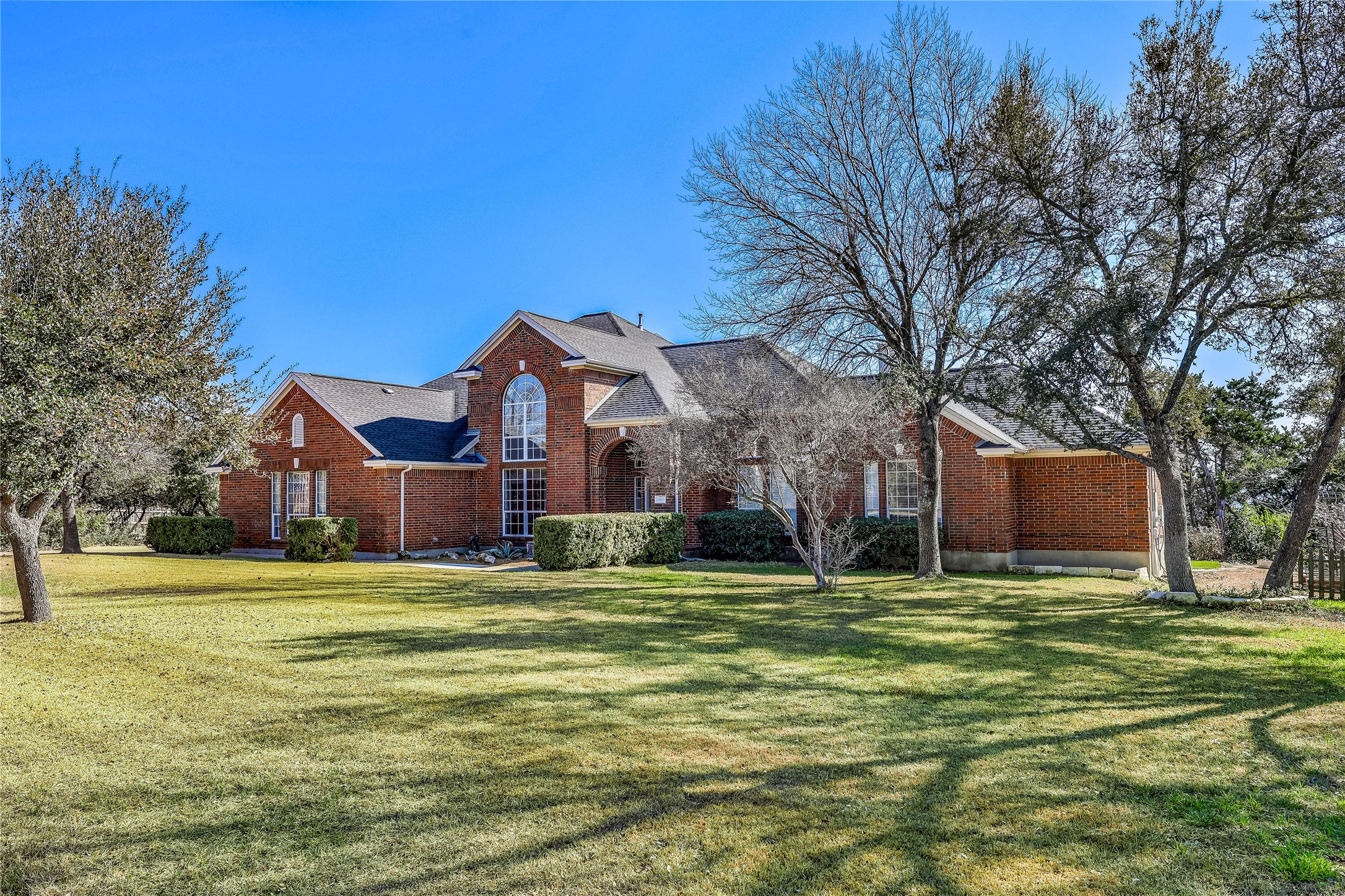 18607 White Rim Trail Jonestown, TX 78645 - Photo 4 of 40 Traditional-style house featuring brick siding and a front lawn