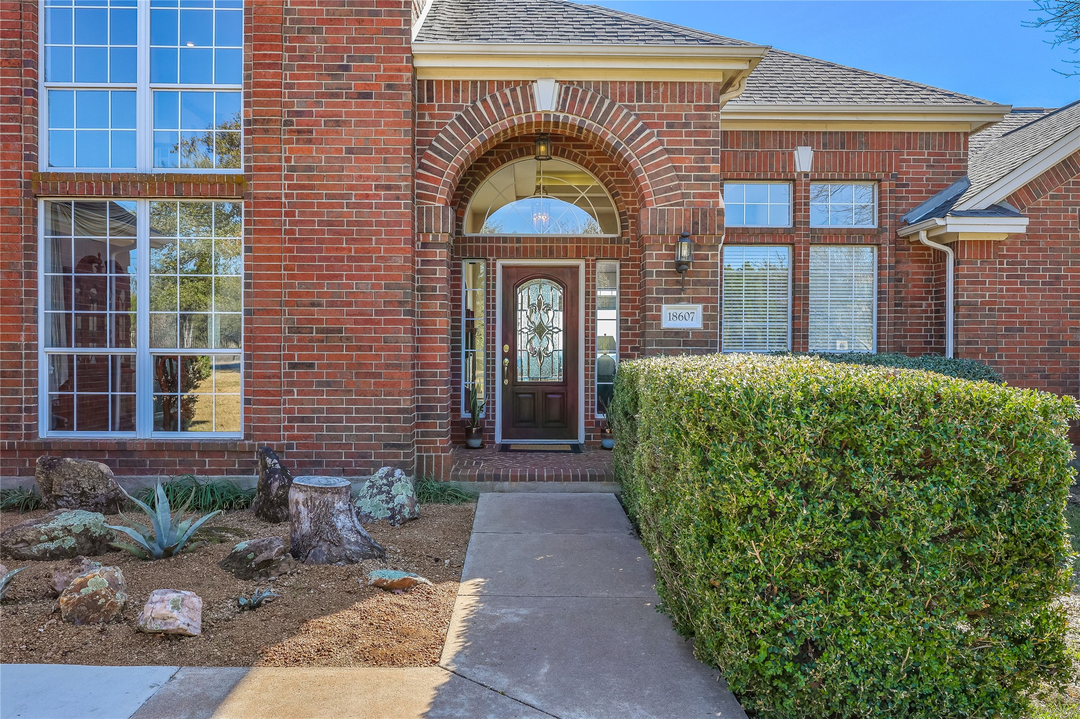 18607 White Rim Trail Jonestown, TX 78645 - Photo 5 of 40 Doorway to property with brick siding and a shingled roof
