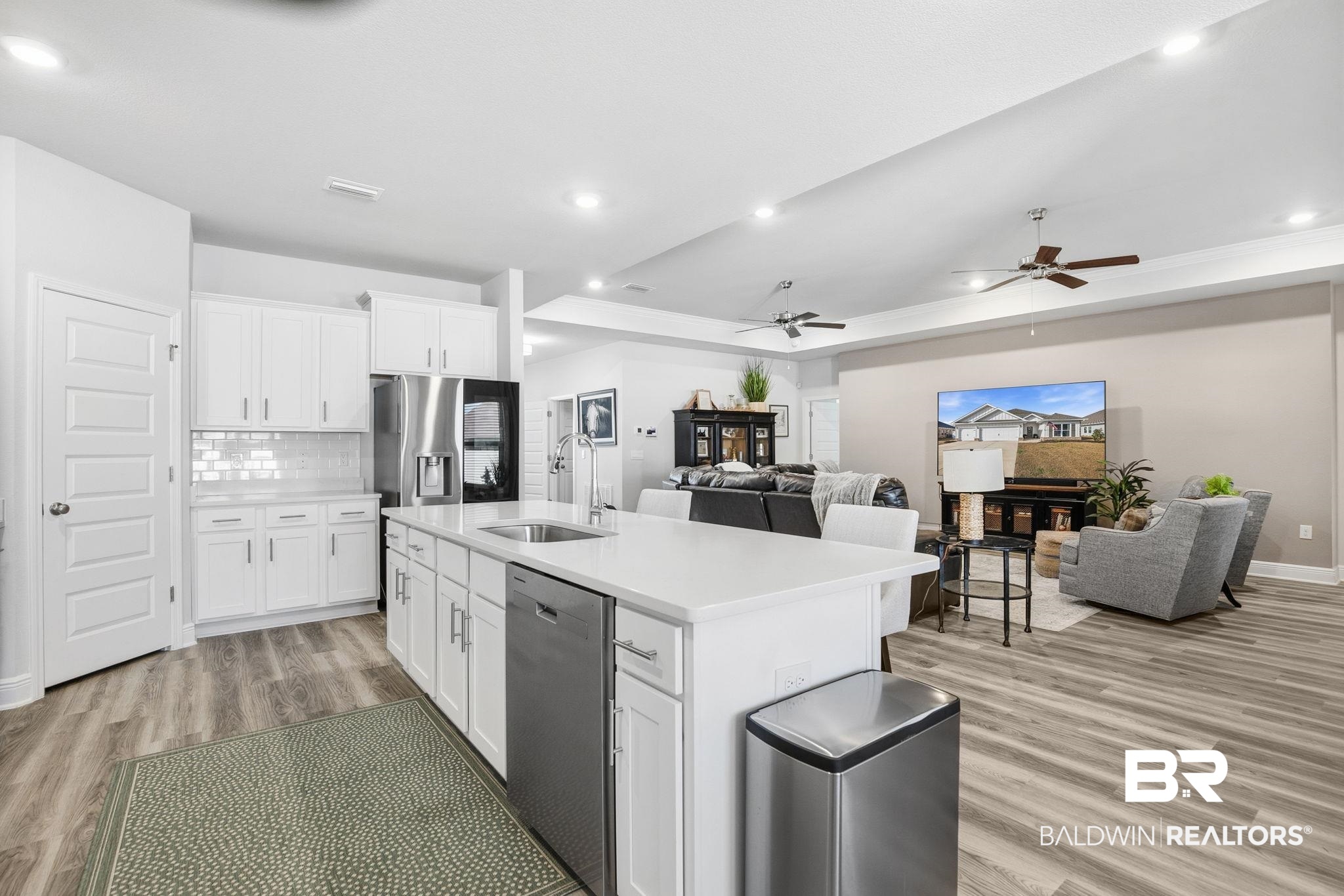 11123 Genuine Risk Circle Daphne, AL 36526 - Photo 65 of 67 Kitchen featuring white cabinetry, stainless steel appliances, light wood finished floors, open floor plan, and a tray ceiling