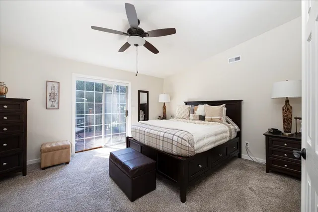 a spacious bedroom with a bed a couch and a chandelier