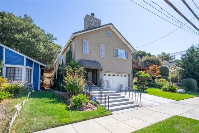 a front view of a house with a garden